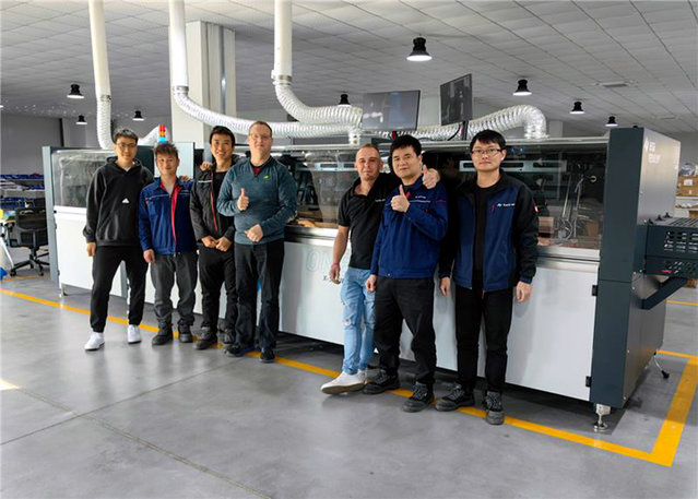Die deutschen und lokalen Ingenieurteams vor der ersten in Zhuhai hergestellten VERSAFLOW ONE Maschine